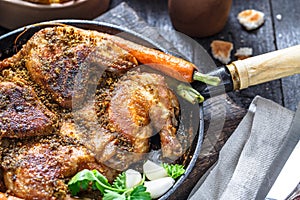 Whole roast chicken in an iron pan, rustic style, close view