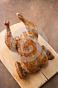 Whole roast chicken on wooden table
