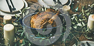 Whole roasted chicken for Christmas, plates and candles