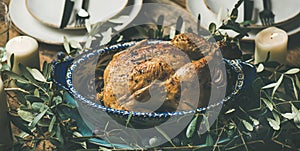 Whole roasted chicken decorated with olive tree branch, selective focus