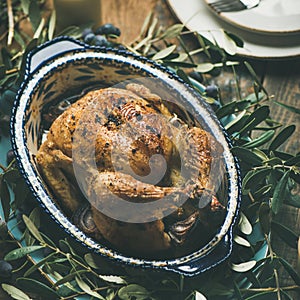 Whole roasted chicken decorated with olive tree branch, square crop