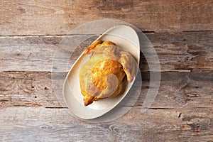 Whole roasted chicken on wooden background. Top view. Copy space. Festive family dinner table