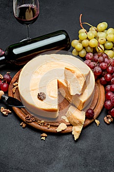 Whole round Head parmesan cheese, wine and grapes