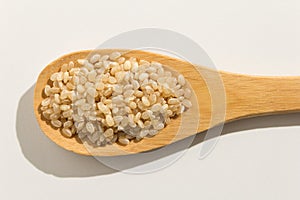 Whole Short Grain Rice Seed. Nutritious grains on a wooden spoon photo