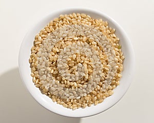 Whole Short Grain Rice Seed. Top view of grains in a bowl. White photo