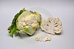 Whole and sliced cauliflowers on a seamless background