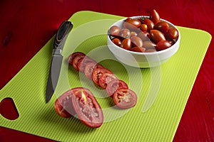 Whole and sliced cherry tomatoes in a white saucer