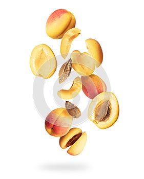 Whole and sliced fresh apricots in the air, isolated on a white background