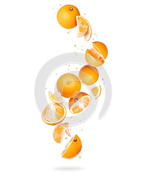 Whole and sliced fresh oranges in the air on a white background