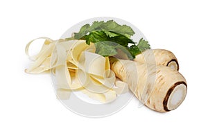 Whole and sliced fresh ripe parsnip with leaves on white background, closeup