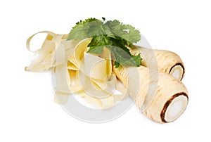 Whole and sliced fresh ripe parsnip with leaves on white background, closeup