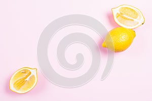 Whole and sliced lemon on pink background