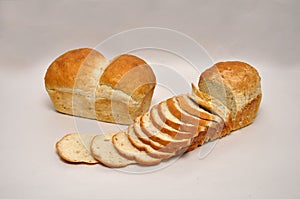 Whole and sliced loaves of wholemeal bread on a seamless background