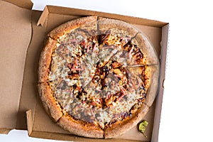 A whole sliced meat barbeque pizza in the delivery box