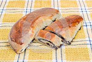 Whole and sliced poppy seed pies on the checkered napkin