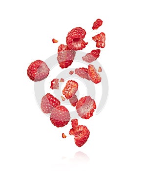 Whole and sliced raspberries in the air, isolated on a white background