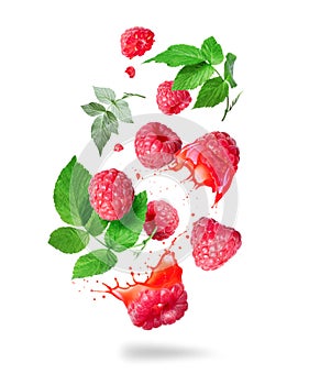 Whole and sliced raspberries with juice splashes in the air isolated on a white background