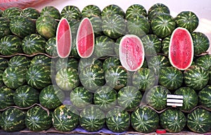 Whole and sliced watermelons at market photo