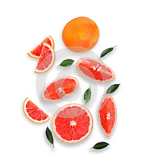 Whole and slices grapefruit with green leaves isolated on white