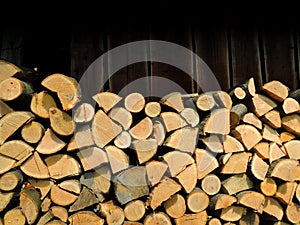 Whole, split in half and chopped oak firewood near the wall of old woodshed