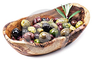 Whole table olives in the wooden bowl.