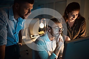 The whole team have their eyes on success. a group of businesspeople working late in an office.