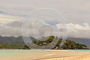 Whole tropical island within atoll in Indian Ocean. Wild subtropical isle with palm trees. Blank sand on a tropical island.