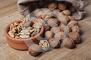 Whole unpeeled and broken walnuts on a white background.