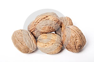 Whole unpeeled and broken walnuts on a white background.