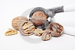 Whole unpeeled and broken walnuts on a white background.