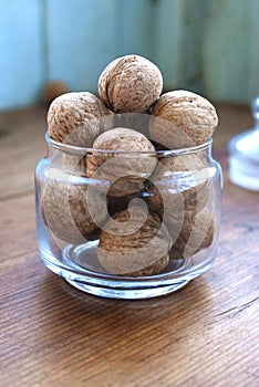 Whole walnut in a glass jar on a wooden table