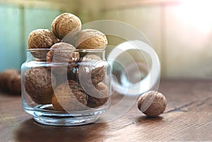 Whole walnut in a glass jar on a wooden table