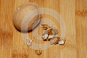 A whole walnut next to a split one on a light background