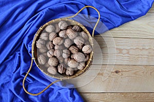 Whole Walnuts in a basket with blue background
