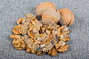 whole walnuts and kernels on burlap background, healthy food