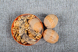 whole walnuts and kernels on burlap background, healthy food