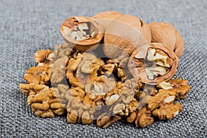 whole walnuts and kernels on burlap background, healthy food