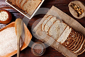 whole wheat bread with grains and seeds sliced on wooden table