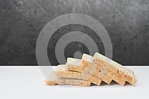 Whole wheat bread lay on a white background with a black wall