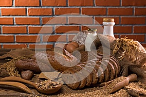 Whole wheat bread,milk,flour and cloth bag on wood table.