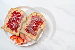 whole wheat bread with strawberry jam and fresh strawberry