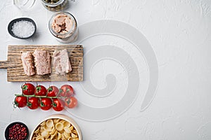Whole wheat pasta with dried tomatoes and tuna ingredients, on white background, top view  with copy space for text