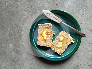 Whole wheat scone with melting butter on plate with knife