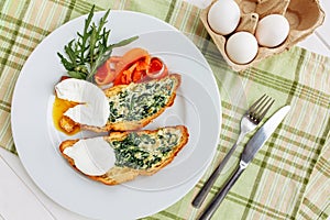 Whole wheat toasted bread with arugula and poached egg, smoked salmon. Table arrengement top view copy space