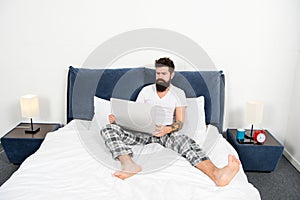 Whole world in his laptop. Man surfing internet or working online. Hipster bearded guy pajamas freelance worker. Remote