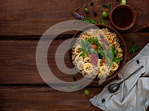 Wholegrain Oatmeal porridge bowl with fresh berries, fruits, nuts mint leaves tea cup. Healthy food oat meal breakfast