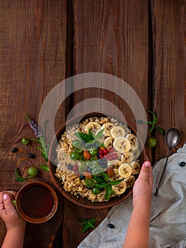 Wholegrain Oatmeal porridge bowl with fresh berries, fruits, nuts mint leaves tea cup. Healthy food oat meal breakfast