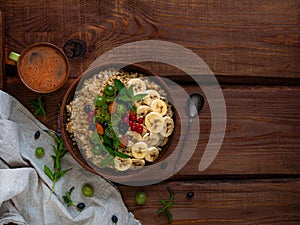 Wholegrain Oatmeal porridge bowl with fresh berries, fruits, nuts mint leaves tea cup. Healthy food oat meal breakfast