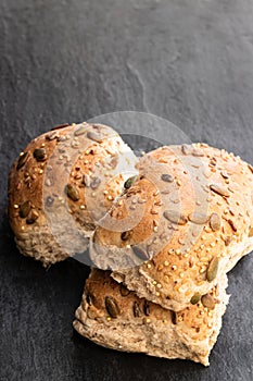 Wholemeal multiseeds batch rolls on black table batch of four