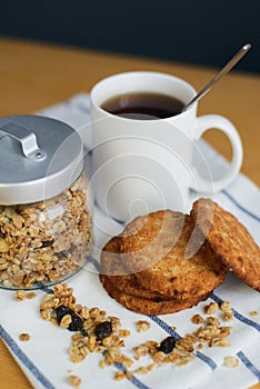 Wholemeal oatmeal cookies stack with granola and tea on napkin